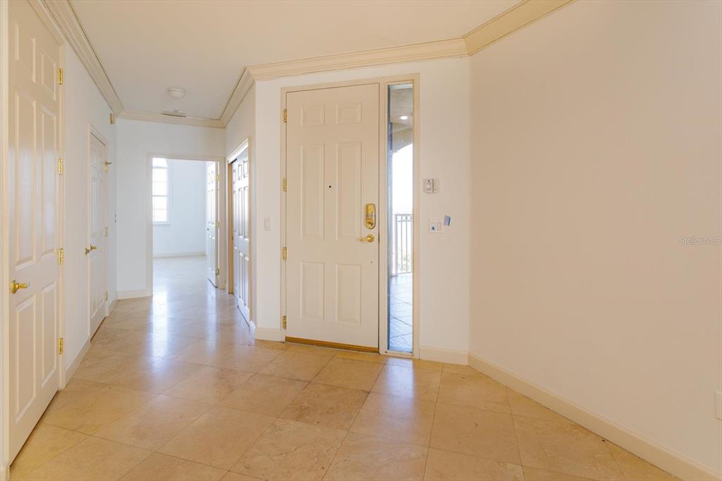 An entryway features a white front door, tiled flooring, and a hallway leading inside — 8761 THE ESPLANADE UNIT 31, ORLANDO, FL