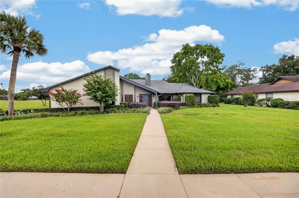 A single-story house with a gray roof, tan siding, and a long walkway through the lawn — 190 CANTERCLUB TRAIL NW, LONGWOOD, FL