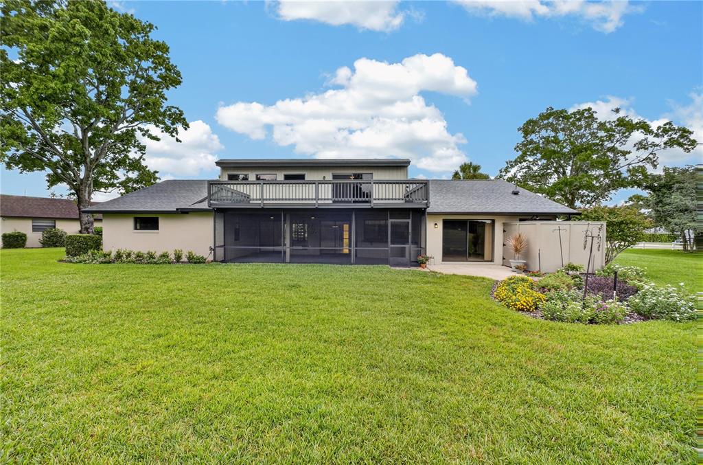 The rear exterior of a two-story house features a screened-in porch and an upper deck — 190 CANTERCLUB TRAIL NW, LONGWOOD, FL