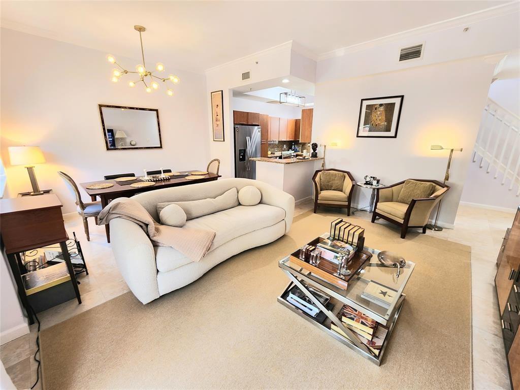 A living room with a curved sofa, glass coffee table, dining area, and open kitchen — 2317 Vintage Drive, Lighthouse Point FL 33064, LIGHTHOUSE POINT, FL