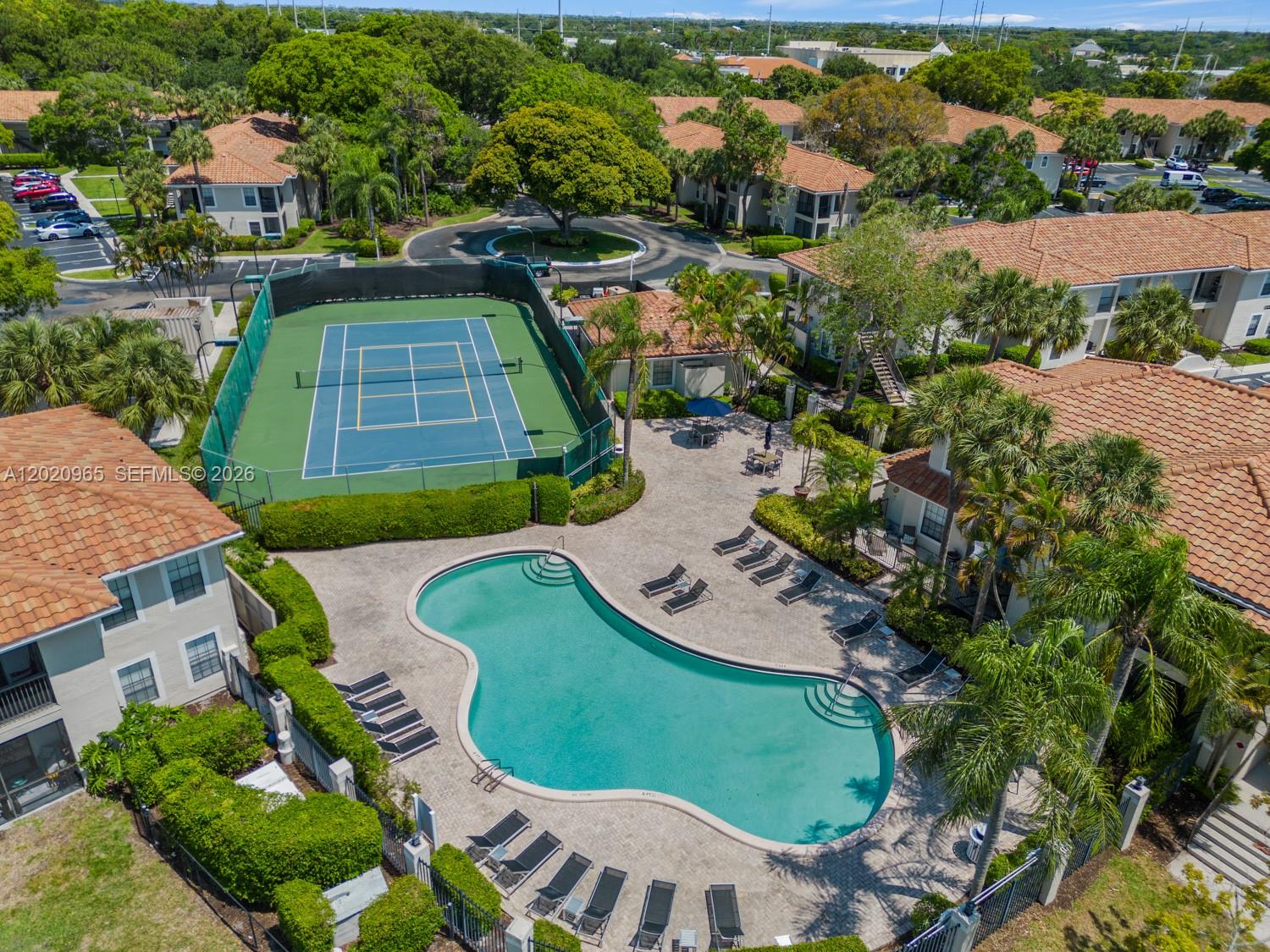 An aerial view shows a community swimming pool and tennis court surrounded by apartment buildings — 6503 N Military Trl, Boca Raton FL 33496, BOCA RATON, FL