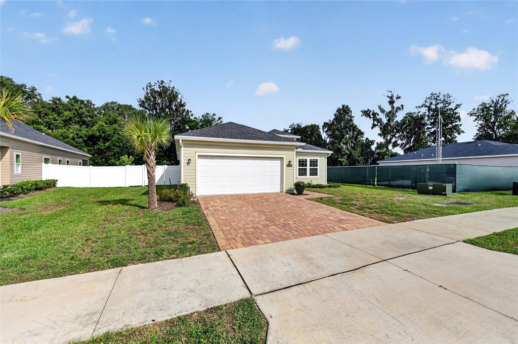 A single-story house with a two-car garage and a paved driveway under a blue sky — 1700 NW 44TH COURT ROAD, OCALA, FL