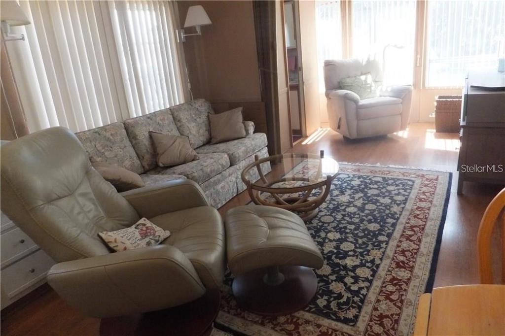 A living room features a floral sofa, a leather recliner with ottoman, and a patterned rug — 351 CITRUS RIDGE DRIVE, DAVENPORT, FL