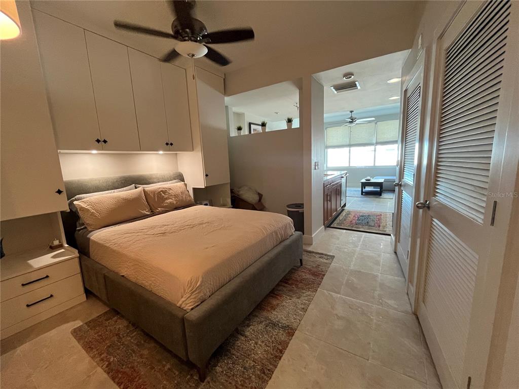 A bedroom features a bed with built-in cabinetry, tile flooring, and an adjacent living area — 1120 E KENNEDY BOULEVARD UNIT 924, TAMPA, FL