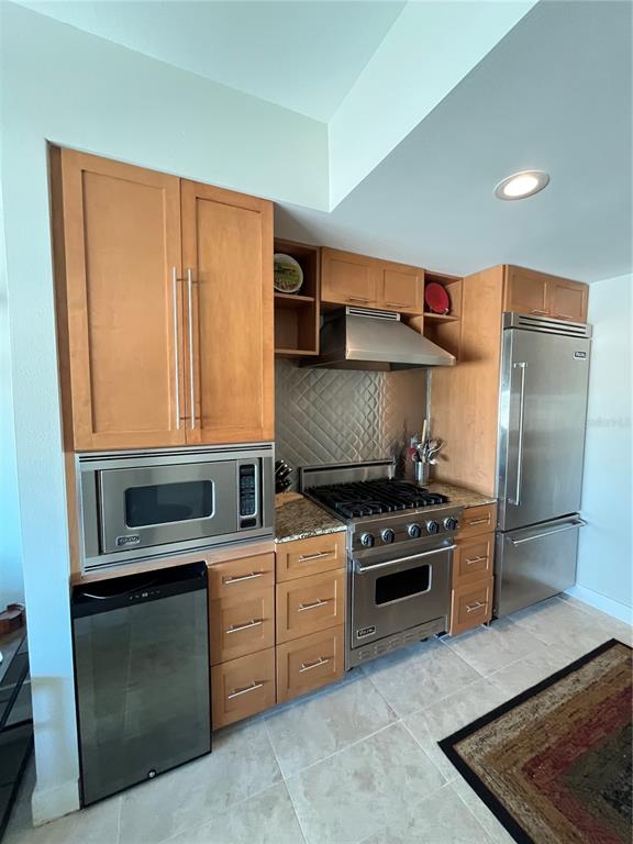 A kitchen features light wood cabinets, stainless steel appliances, and a tiled floor — 1120 E KENNEDY BOULEVARD UNIT 924, TAMPA, FL