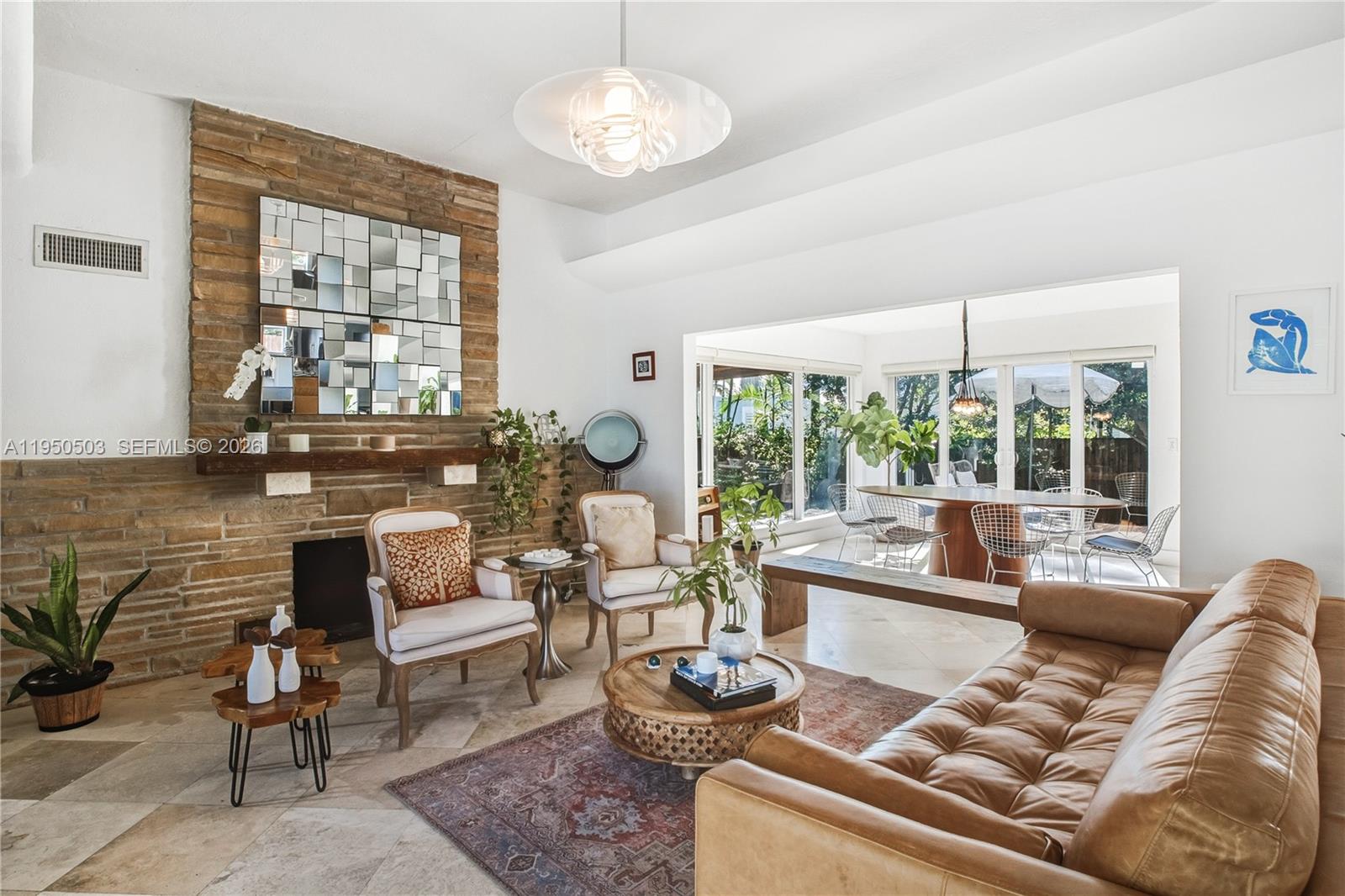 A living room features a stone fireplace, leather sofa, and an adjacent dining area — 1106 NE 86th St, Miami FL 33138, MIAMI, FL
