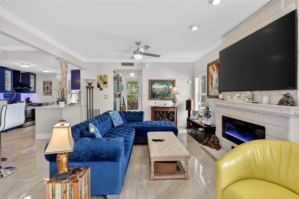 A living room features a blue sectional sofa, a yellow armchair, and a fireplace — 1524 SE 12TH STREET UNIT 6, FORT LAUDERDALE, FL