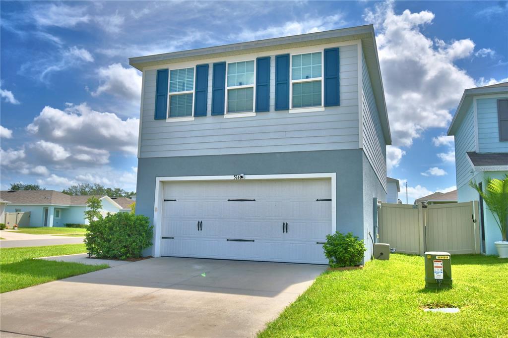 A two-story house with a light blue exterior, a two-car garage, and blue window shutters — 5148 HELM STREET, HAINES CITY, FL