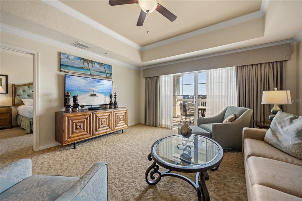 A living room features a television, a glass coffee table, and a balcony view — 1114 SUNSET VIEW CIRCLE UNIT 402, REUNION, FL
