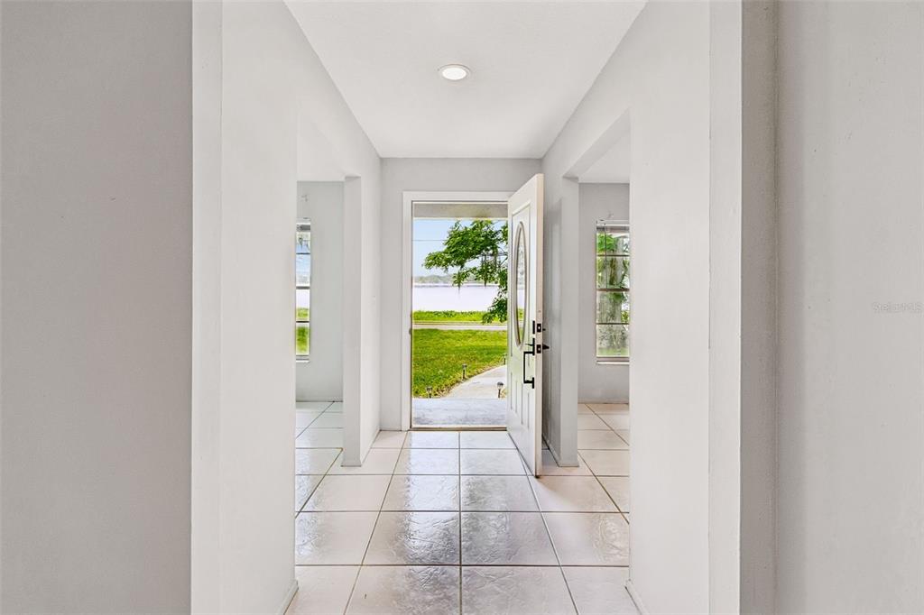 A tiled entryway leads to an open front door with a view of a lake — 400 E SILVER STAR ROAD, OCOEE, FL