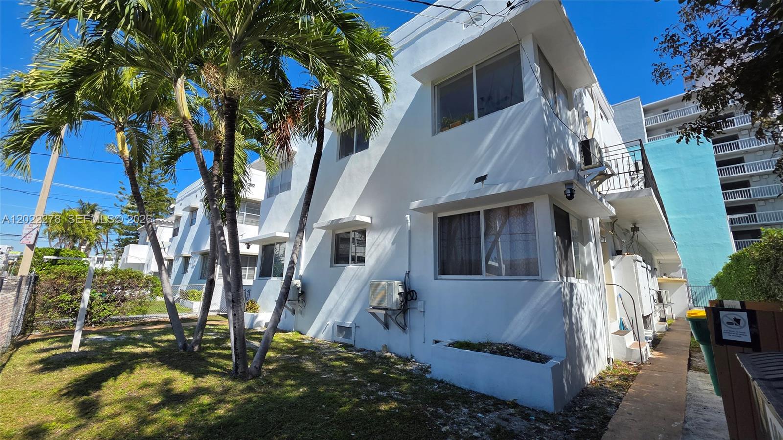 An empty room features white walls, light-colored tile flooring, and two large windows — 7629 Dickens Ave # 8, Miami Beach FL 33141, MIAMI BEACH, FL