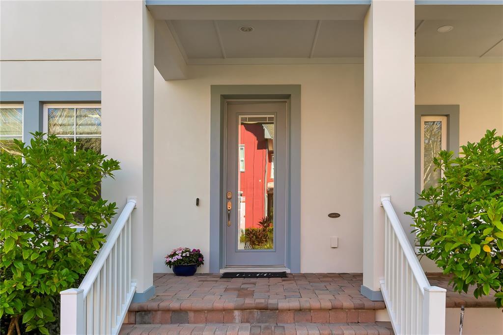 The front entrance features a gray door with a glass panel, brick steps, and railings — 14080 AGRE LANE, ORLANDO, FL