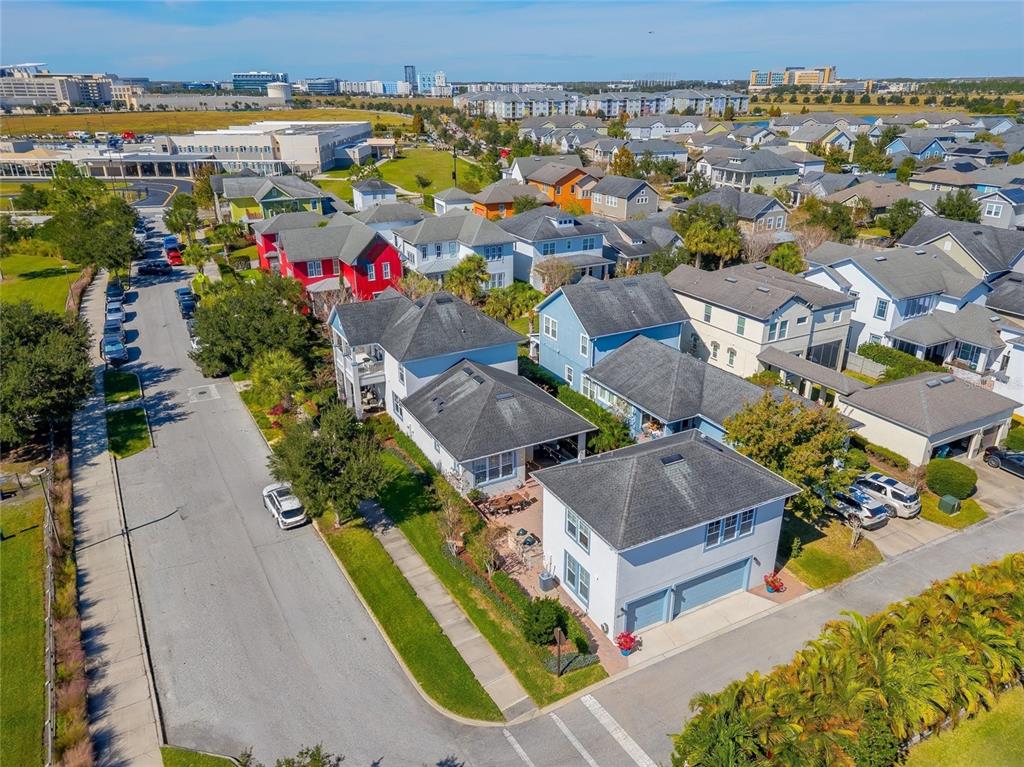 An aerial view shows a suburban neighborhood with colorful houses, paved streets, and parked cars — 14080 AGRE LANE, ORLANDO, FL