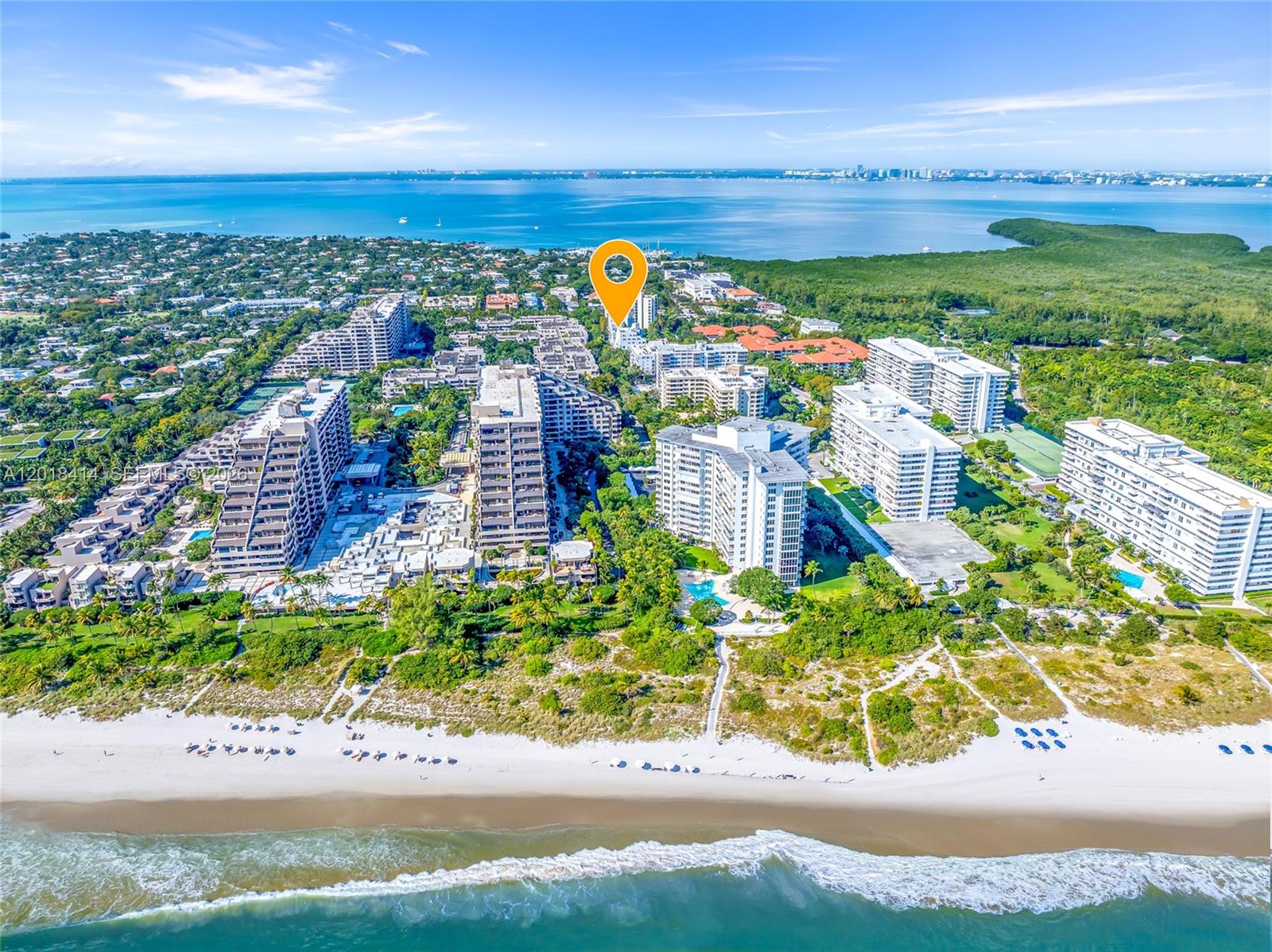 An aerial view shows multiple high-rise residential buildings situated along a sandy beach and ocean — 50 Ocean Lane Dr, Key Biscayne FL 33149, KEY BISCAYNE, FL