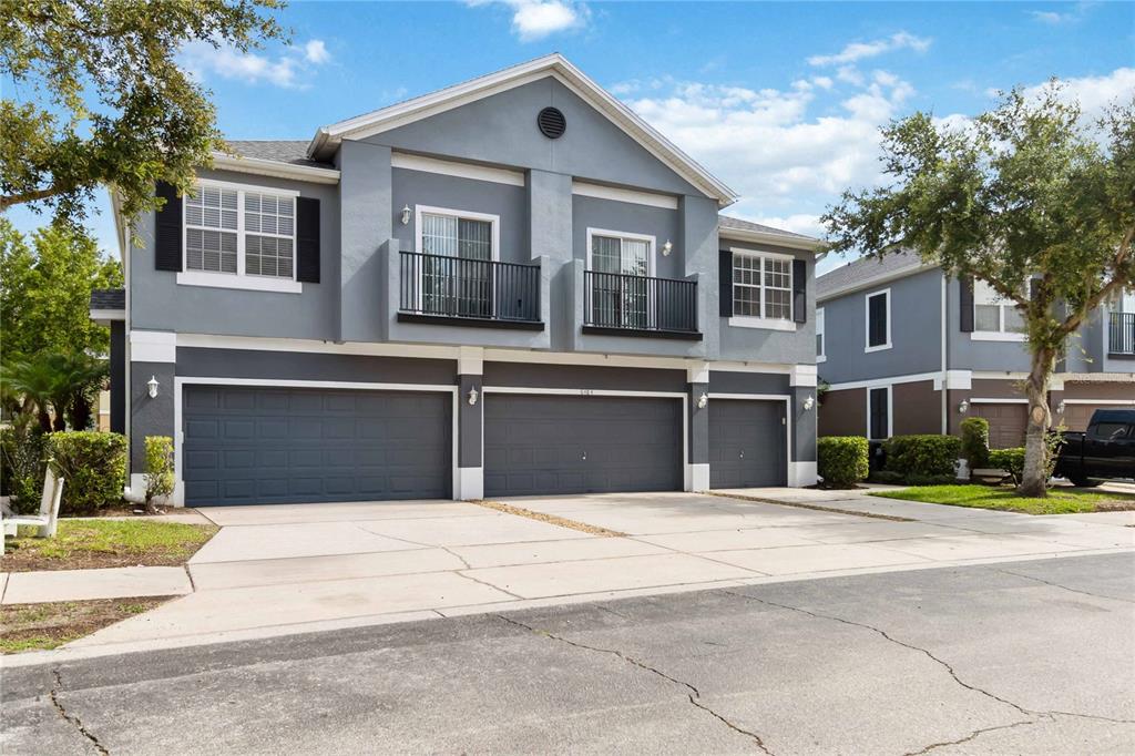 A two-story gray townhouse with three garage doors and two upper-level balconies — 6484 S GOLDENROD ROAD UNIT 41A, ORLANDO, FL