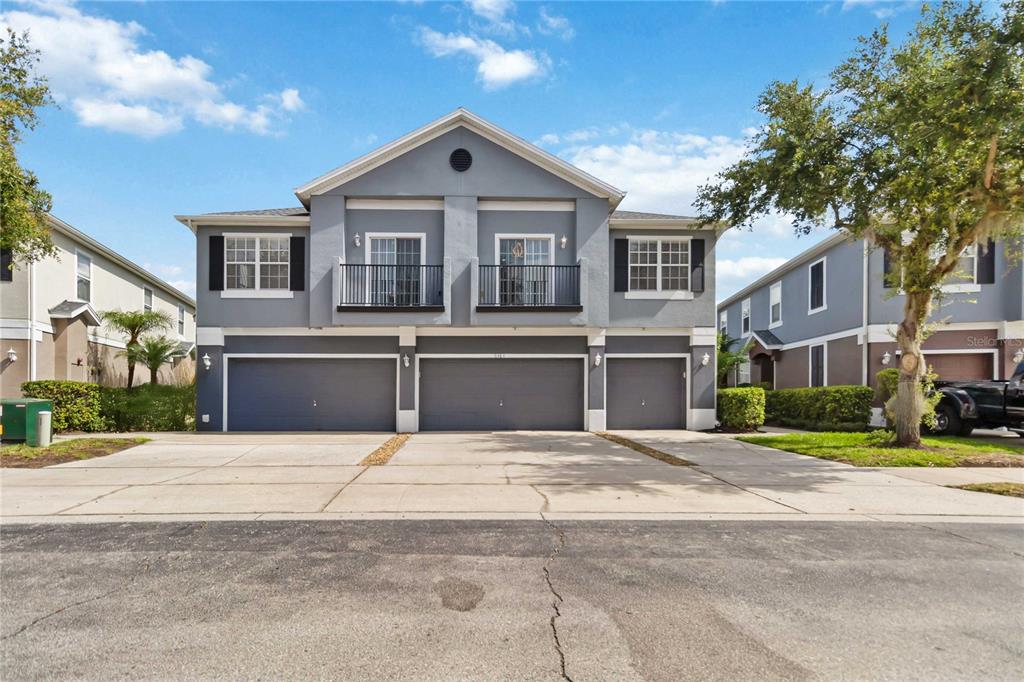 A two-story gray townhouse exterior features three garage doors and two upper-level balconies — 6484 S GOLDENROD ROAD UNIT 41A, ORLANDO, FL