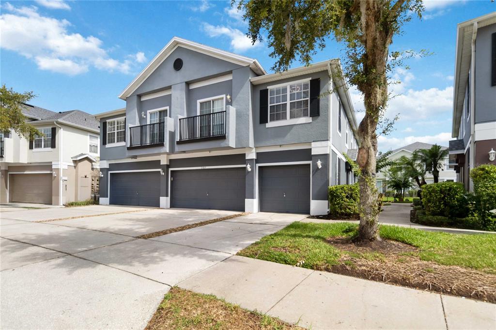 A two-story gray townhouse features three garage doors and two upper-level balconies — 6484 S GOLDENROD ROAD UNIT 41A, ORLANDO, FL