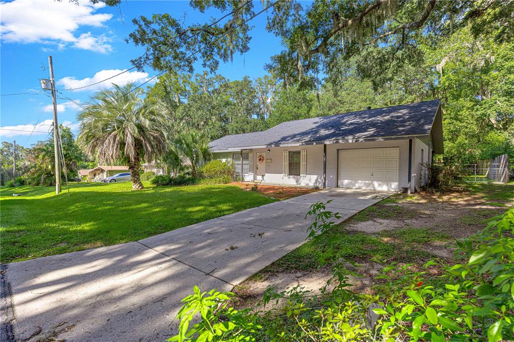 A single-story house with a white exterior, a garage, and a concrete driveway — 716 SE 31ST AVENUE, OCALA, FL