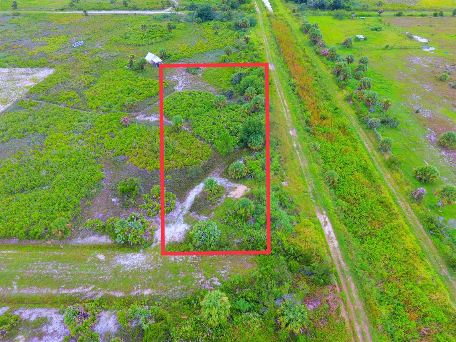 An aerial view shows a rectangular plot of land outlined in red near a dirt path — 21594 NW 282nd Street, Okeechobee FL 34972, OKEECHOBEE, FL