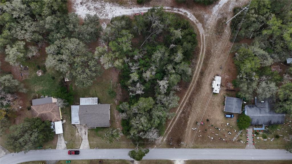 An aerial view shows two houses separated by a wooded area along a paved road — 7800 E SAVANNAH DRIVE, FLORAL CITY, FL