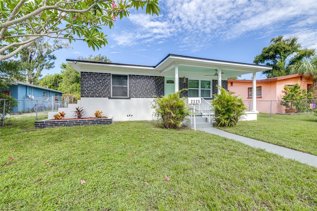 A single-story house with a black brick facade, white lower walls, and a front porch — 2325 HIGHLAND STREET S, ST PETERSBURG, FL