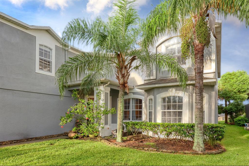A two-story gray house with a palm tree, landscaping, and a grassy front yard — 13412 FOX GLOVE STREET, WINTER GARDEN, FL
