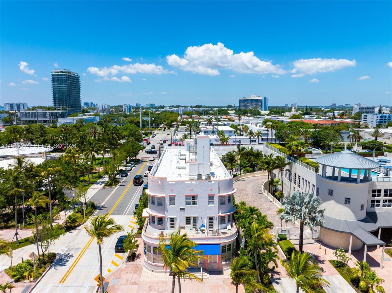 An aerial view shows a light-colored Art Deco building surrounded by palm trees and streets — 7300 Ocean Ter, Miami Beach FL 33141, MIAMI BEACH, FL