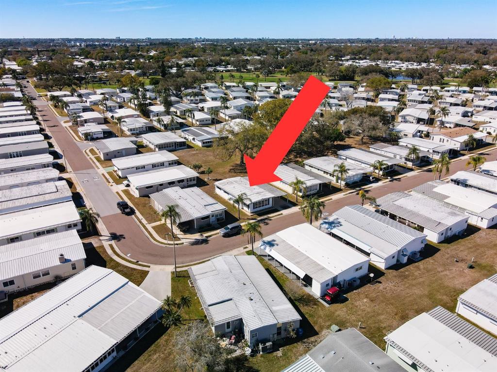 An aerial view shows a single-story mobile home with a red arrow pointing toward it — 1100 BELCHER ROAD S UNIT 561, LARGO, FL
