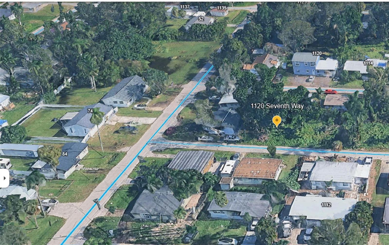 This aerial view shows a residential neighborhood with houses, trees, and a street — 1120 7th Way, FL 33903, FL