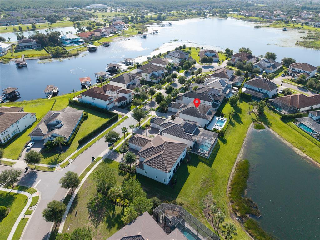 An aerial view shows a residential neighborhood with houses, swimming pools, and a large lake — 7467 JOHN HANCOCK DRIVE, WINTER GARDEN, FL