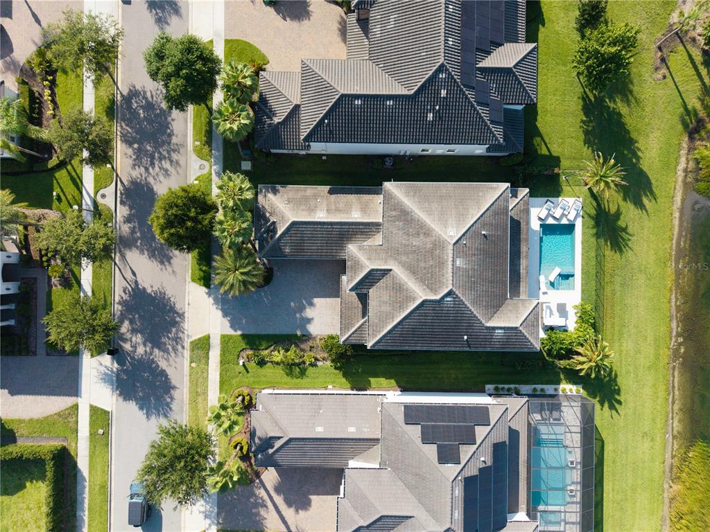 Aerial view of three suburban houses with swimming pools and paved driveways — 7467 JOHN HANCOCK DRIVE, WINTER GARDEN, FL
