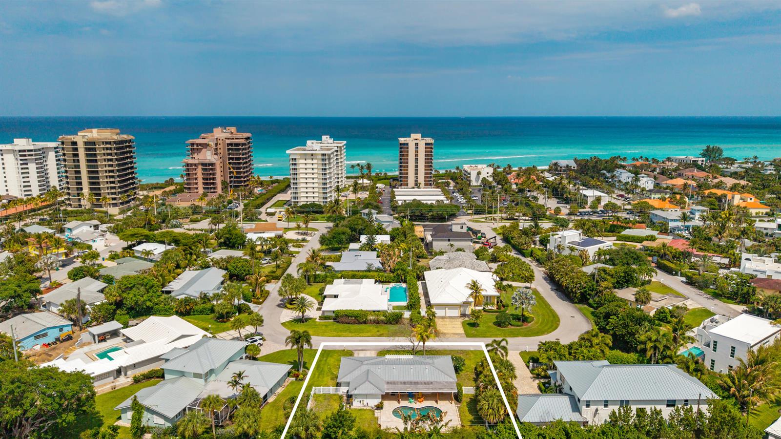 An aerial view of a coastal neighborhood featuring a house with a pool and yard — 461 Apollo Drive, Juno Beach FL 33408, JUNO BEACH, FL