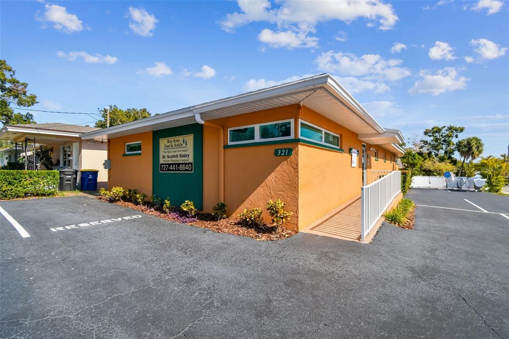 The exterior of an orange commercial building features a wheelchair ramp and a parking lot — 321 S LINCOLN AVENUE, CLEARWATER, FL