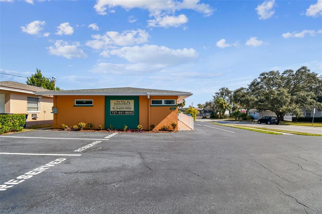 A single-story orange commercial building with a parking lot in the foreground — 321 S LINCOLN AVENUE, CLEARWATER, FL