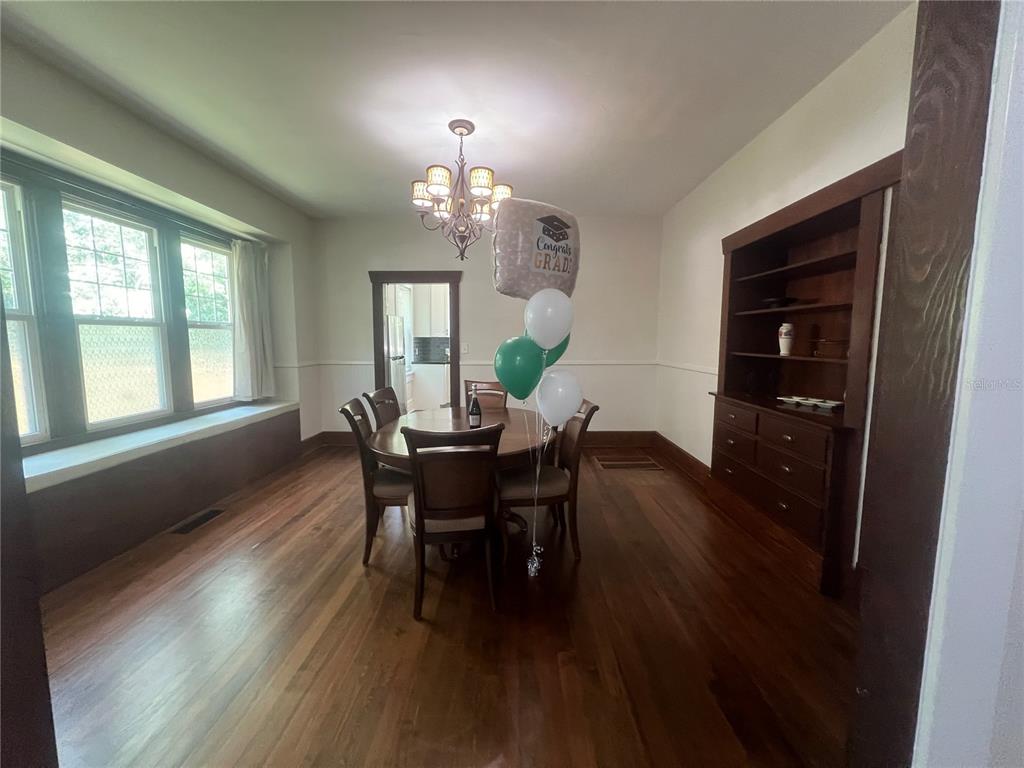 A dining room with hardwood floors, a wooden hutch, and a table with balloons — 134 N STONE STREET, DELAND, FL