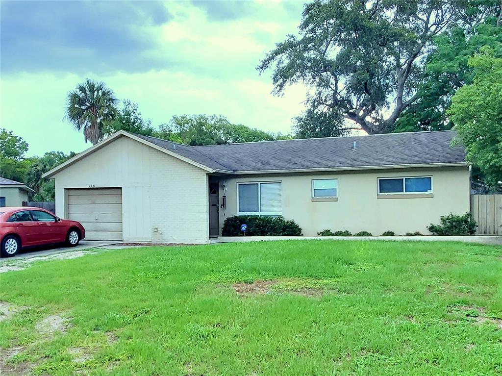 A single-story house with a beige exterior, a garage, and a front lawn — 7731 MARIAH COURT, ORLANDO, FL