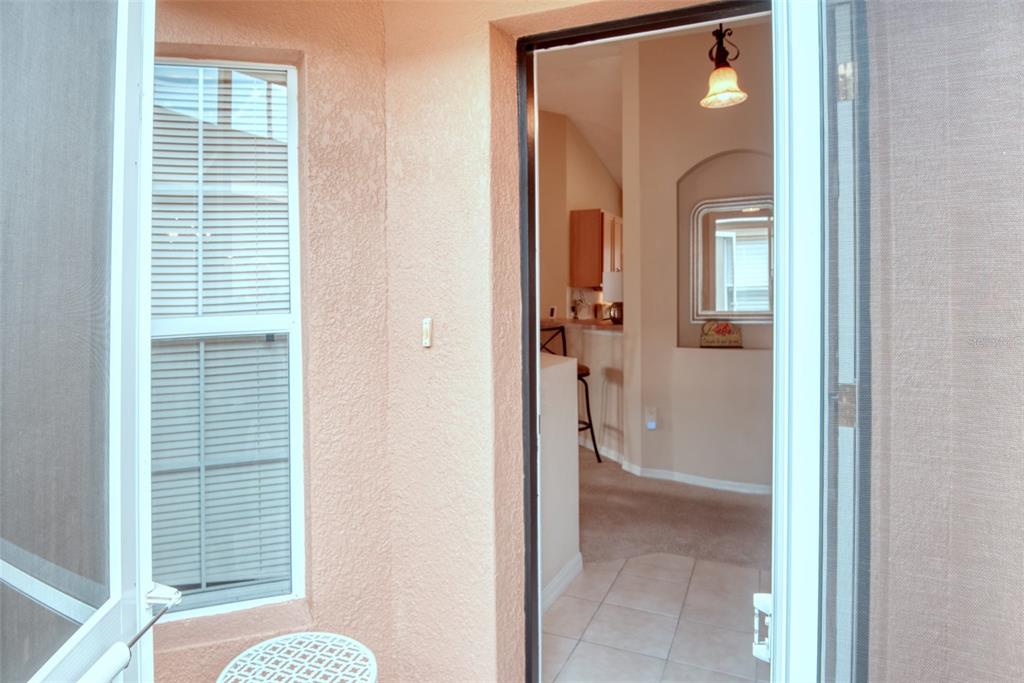 A view through a doorway shows a tiled entryway leading into a carpeted living area — 601 GRAND CANAL DRIVE, KISSIMMEE, FL
