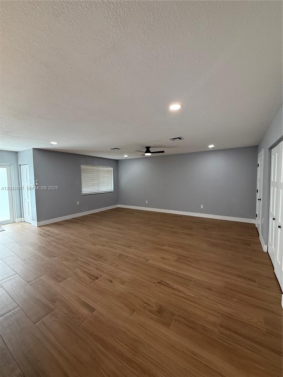An empty room features light gray walls, wood-look tile flooring, and a ceiling fan — 311 NW 33rd Ter, Lauderhill FL 33311, LAUDERHILL, FL