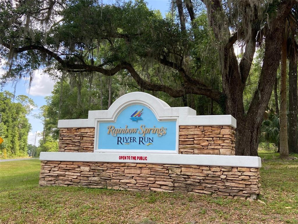 A stone monument sign for Rainbow Springs River Run stands beneath large, moss-covered oak trees — Lot 28 SW 206 CIRCLE, DUNNELLON, FL