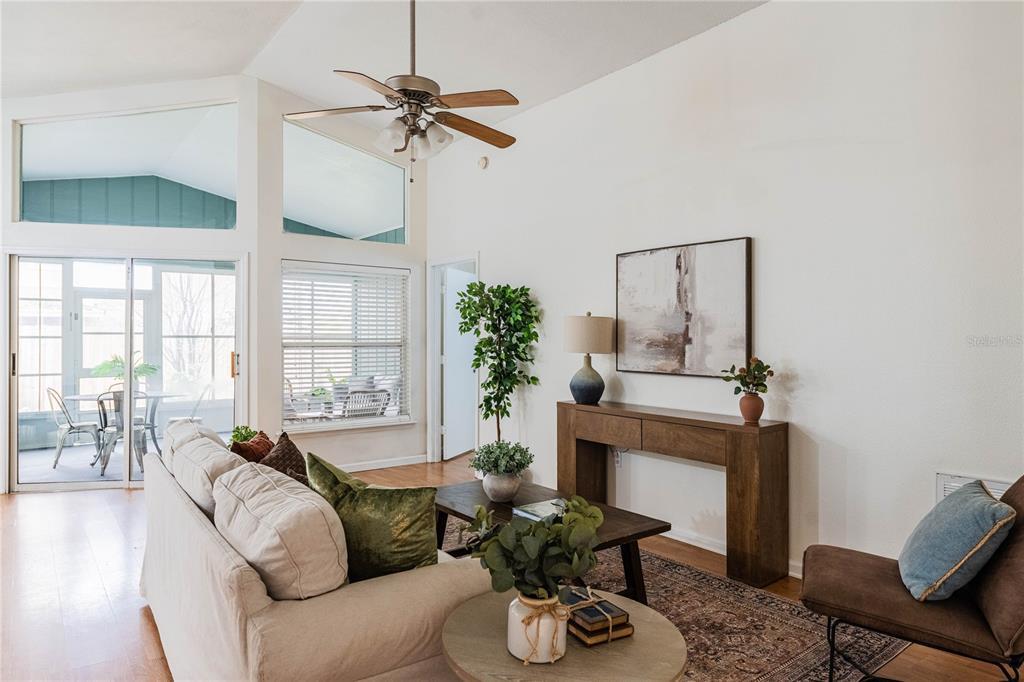 A living room features a vaulted ceiling, a ceiling fan, a sofa, and a console table — 1695 LAKESIDE DRIVE, BARTOW, FL
