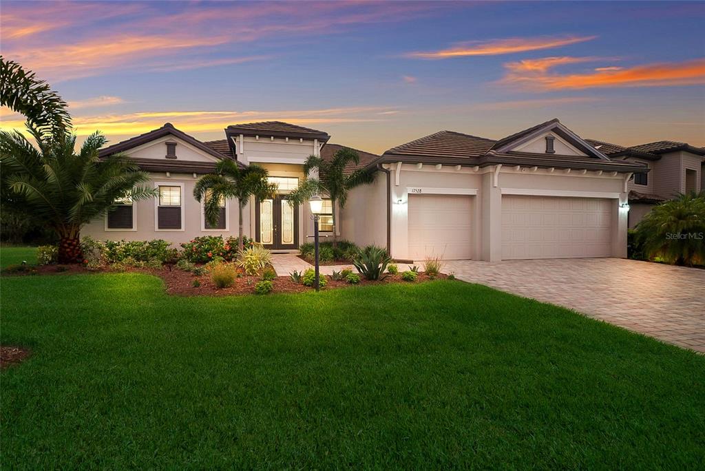 A single-story suburban house with a paved driveway, two-car garage, and landscaped front yard — 17528 POLO TRAIL, LAKEWOOD RANCH, FL