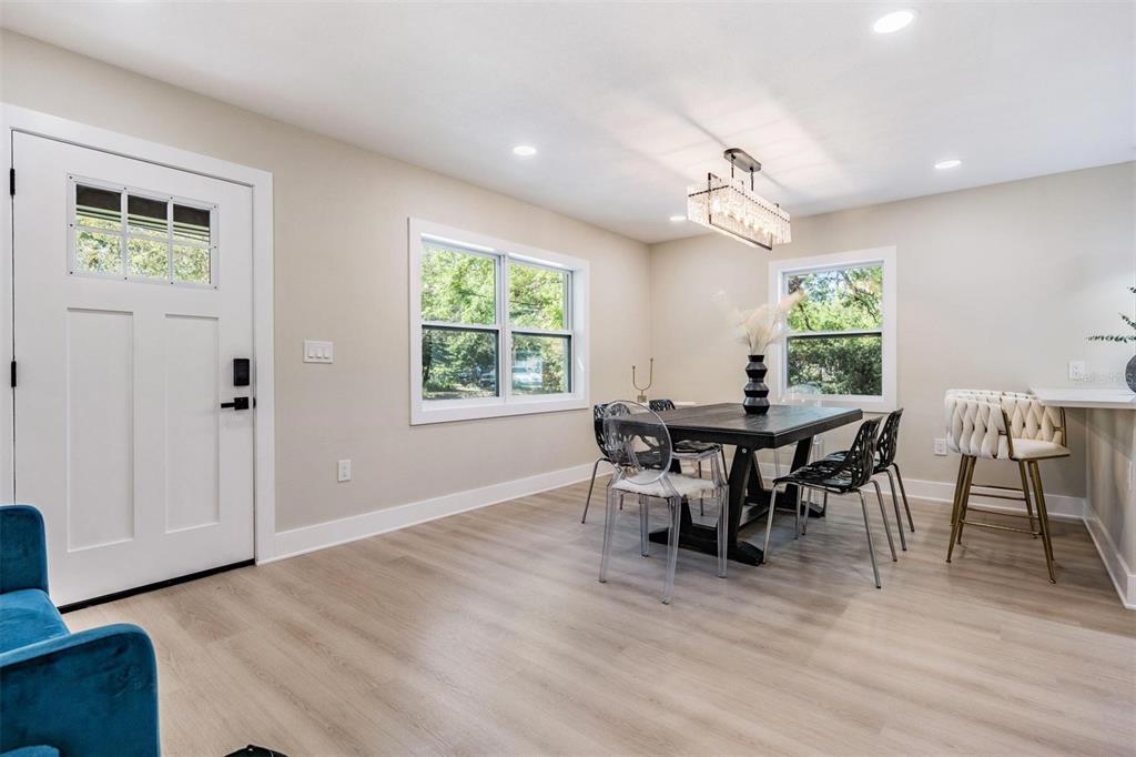 A dining area features a dark wood table, clear chairs, and a rectangular crystal chandelier — 1104 S LOIS AVENUE, TAMPA, FL