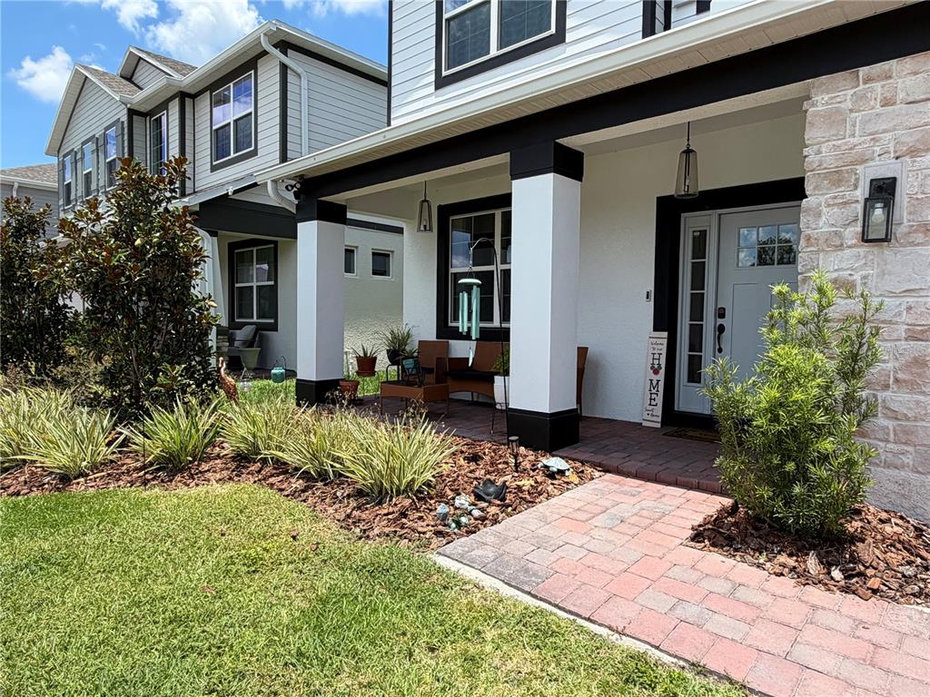 A covered balcony with gray composite decking overlooks a pond and a grassy field — 3743 BRANDING IRON BEND, ST CLOUD, FL