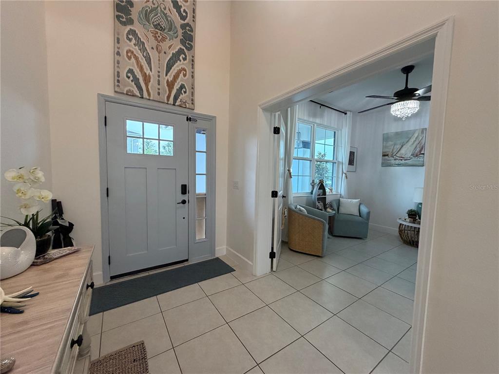 A living room features a beige sofa, two blue armchairs, a ceiling fan, and artwork — 3743 BRANDING IRON BEND, ST CLOUD, FL