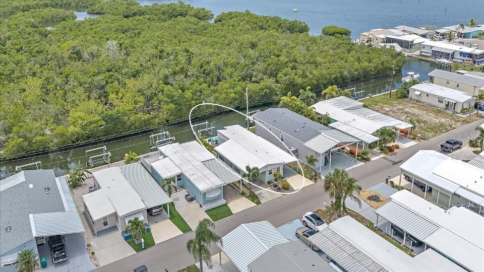 An aerial view shows a row of manufactured homes along a canal with mangroves — 192 BIMINI DRIVE, PALMETTO, FL
