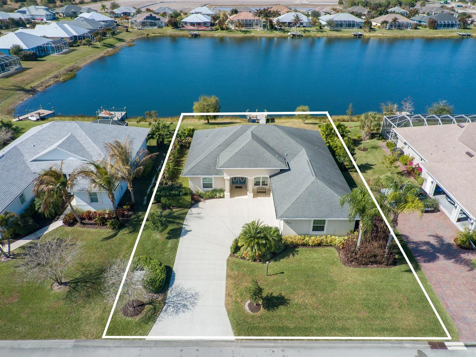 An aerial view shows a single-story house with a gray roof and concrete driveway — 907 Yearling Trail, Sebastian FL 32958, SEBASTIAN, FL