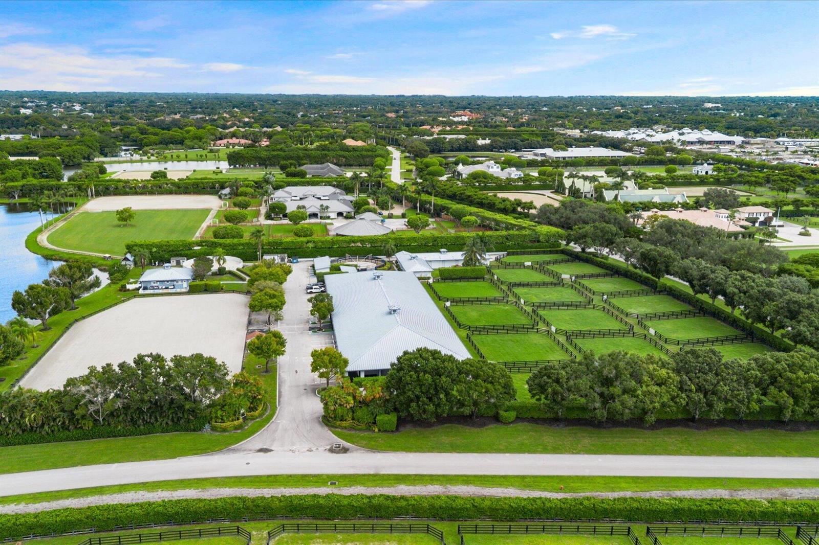 An aerial view shows a large equestrian estate with a barn, paddocks, and riding arenas — 3604 Olde Hampton Drive # 1h, Wellington FL 33414, WELLINGTON, FL