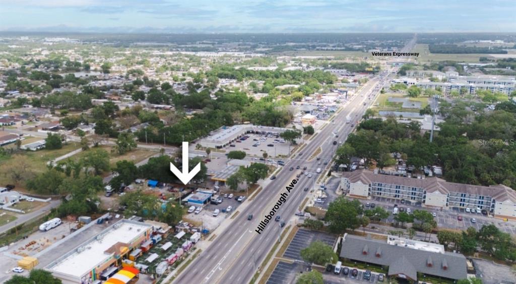 An aerial view shows a commercial property lot located along a busy multi-lane road — 6923 W HILLSBOROUGH AVENUE, TAMPA, FL