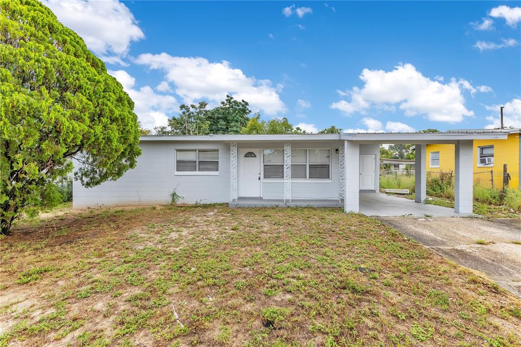 A single-story house with light gray siding, a front porch, and an attached carport — 6132 W LIVINGSTON STREET, ORLANDO, FL