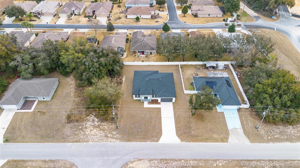 An aerial view shows a suburban neighborhood with several single-family homes and large grassy lots — 16367 SW 16TH COURT, OCALA, FL